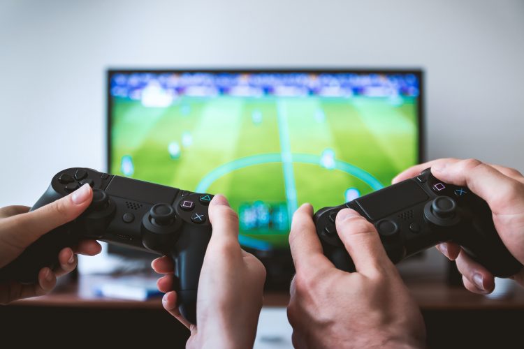 two people playing a video game after setting up a gaming room in your new home